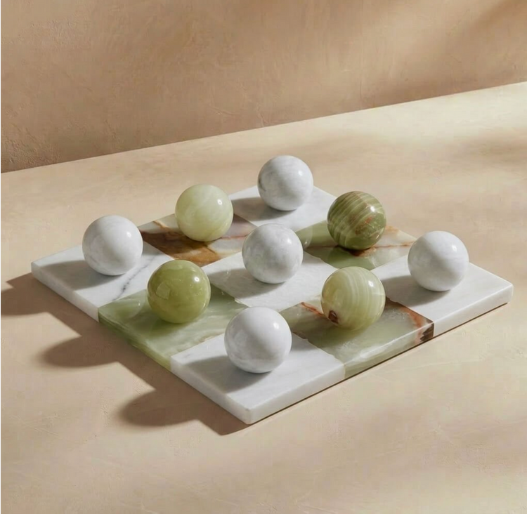 Green onyx and white marble tic tac toe board with spherical playing pieces, angled view