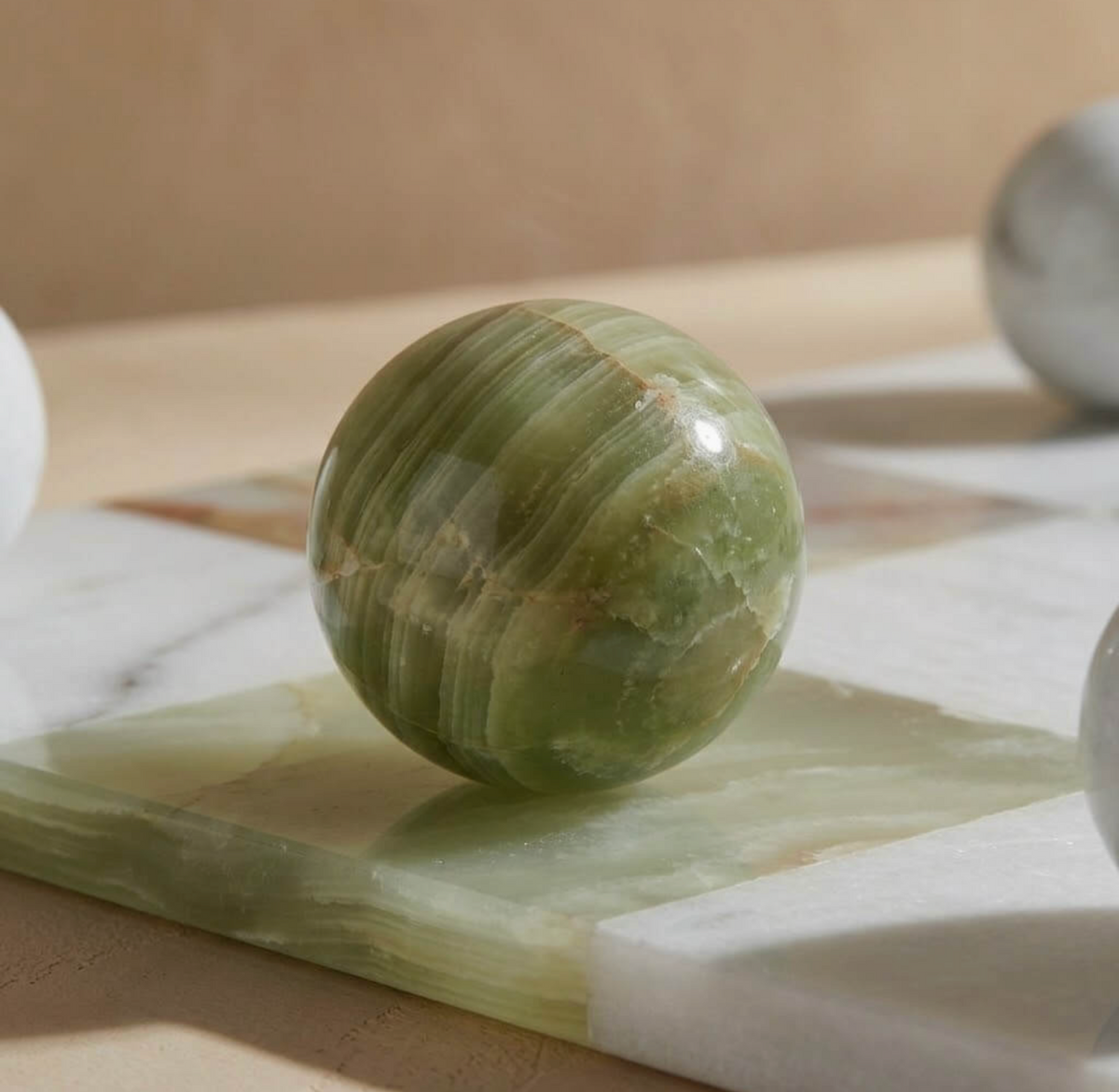 Close-up of green onyx spherical playing piece on the stone board